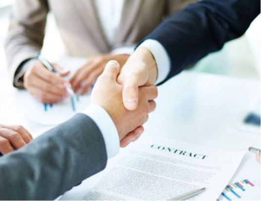 Two men shaking hands in agreement over a contract.