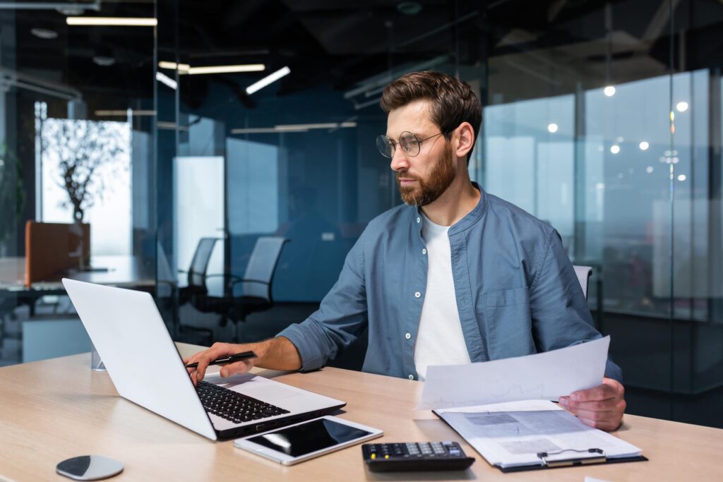 Young business man working at his desk and looking at paperwork.